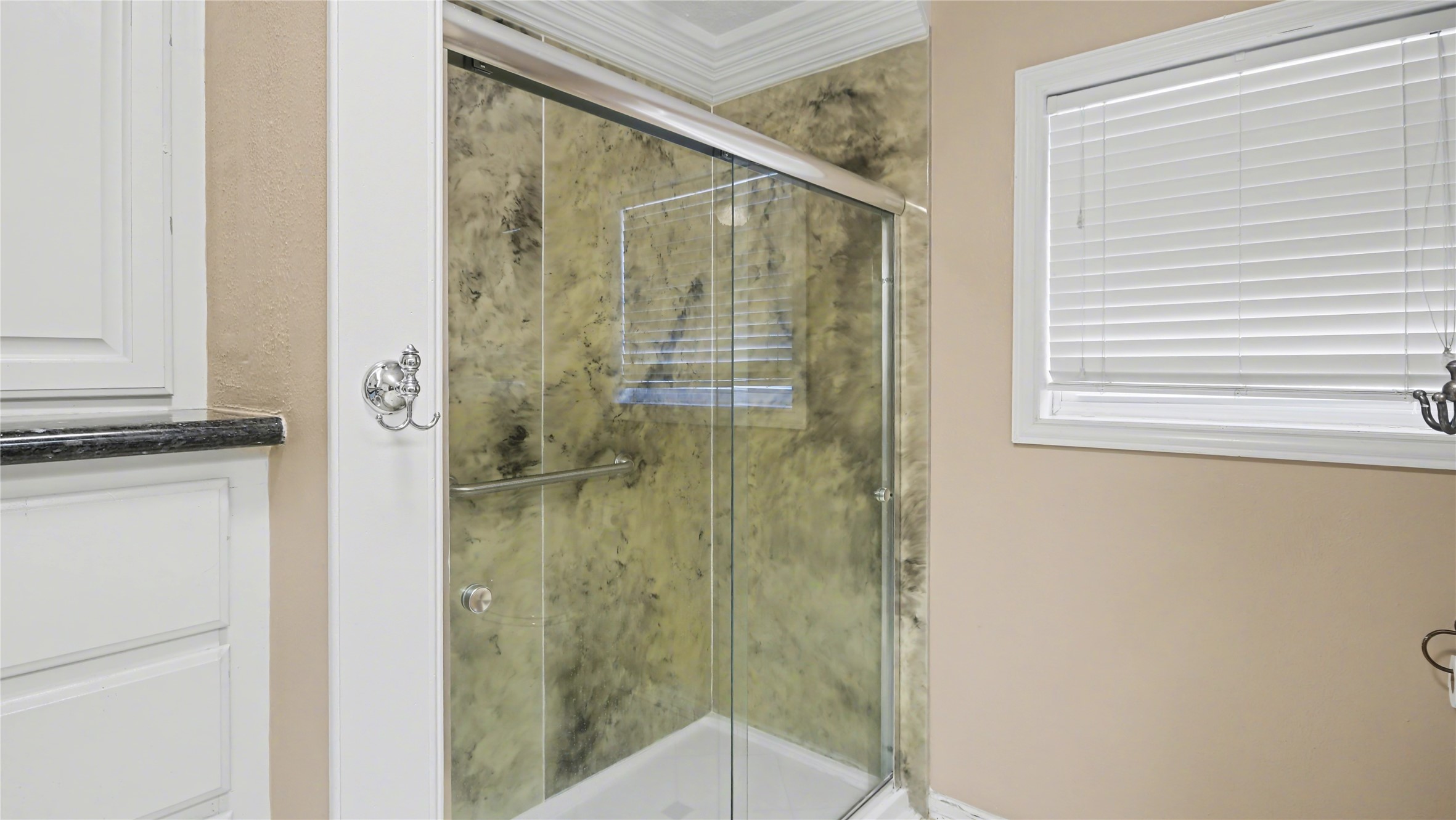 1431 Walnut Lane Houston, TX 77339 - Photo 22 of 44 This elegant bathroom features a sleek glass-enclosed shower with a sophisticated marble-like backdrop, enhanced by soft natural light from the window, creating a serene and stylish retreat.