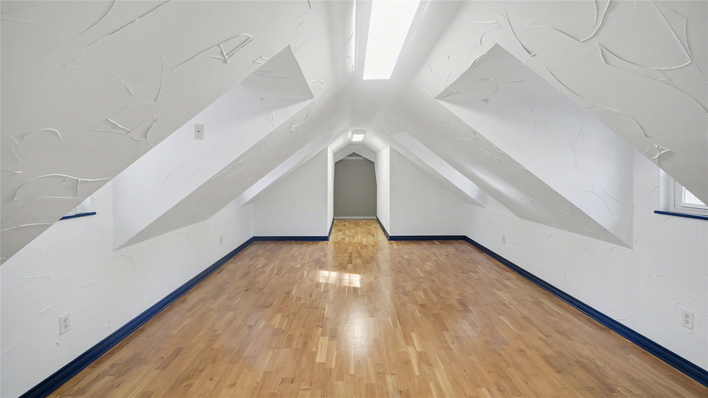1431 Walnut Lane Houston, TX 77339 - Photo 28 of 46 2nd floor flex space with white textured walls, sloped ceilings, and light wood flooring. Natural light enters through a skylight and a small window, creating an inviting atmosphere. Ideal for a cozy loft or storage area.