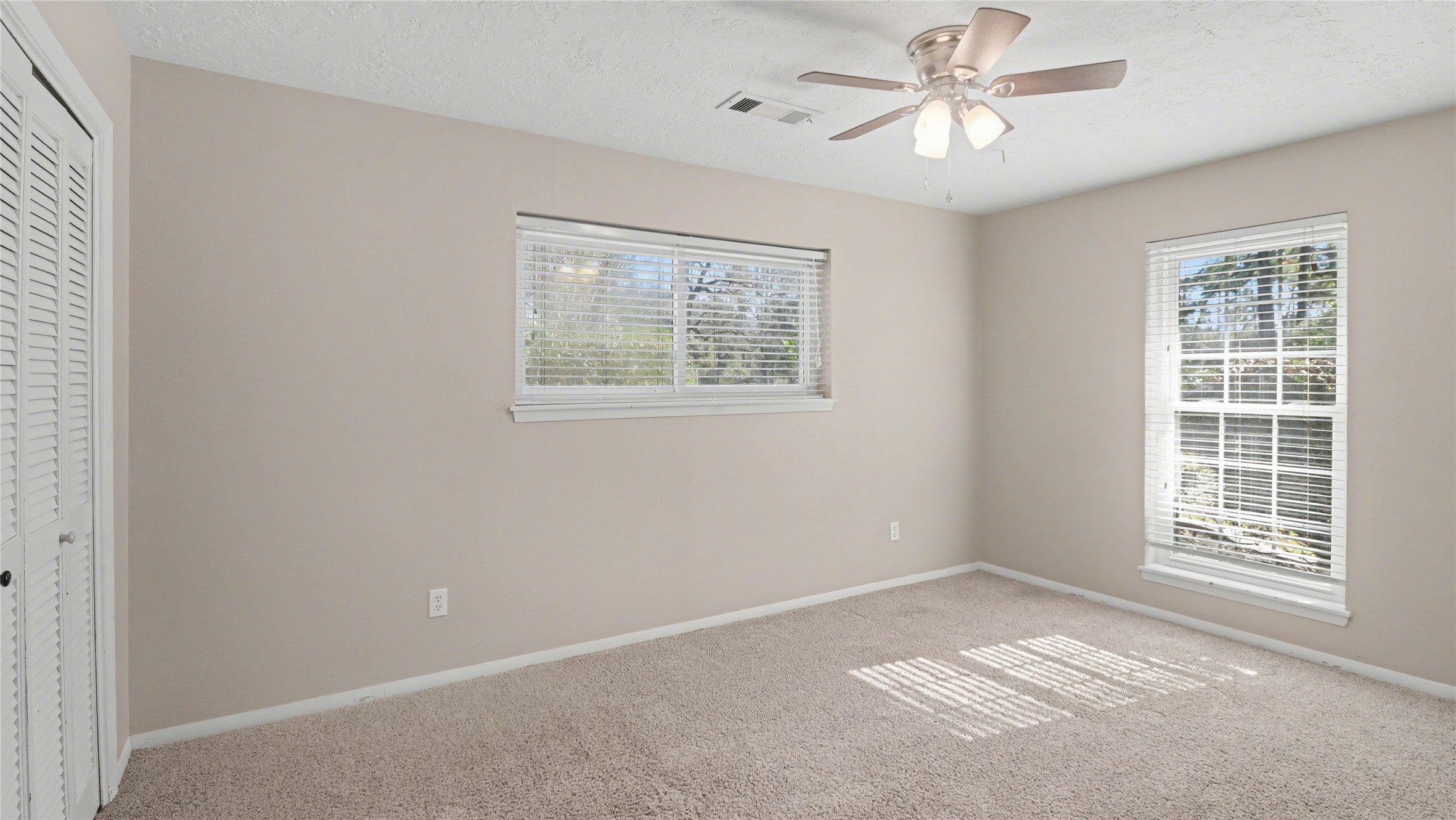 1431 Walnut Lane Houston, TX 77339 - Photo 30 of 46 This inviting bedroom boasts abundant natural light, soft carpeting, and a soothing neutral palette, promising a serene and cozy retreat.