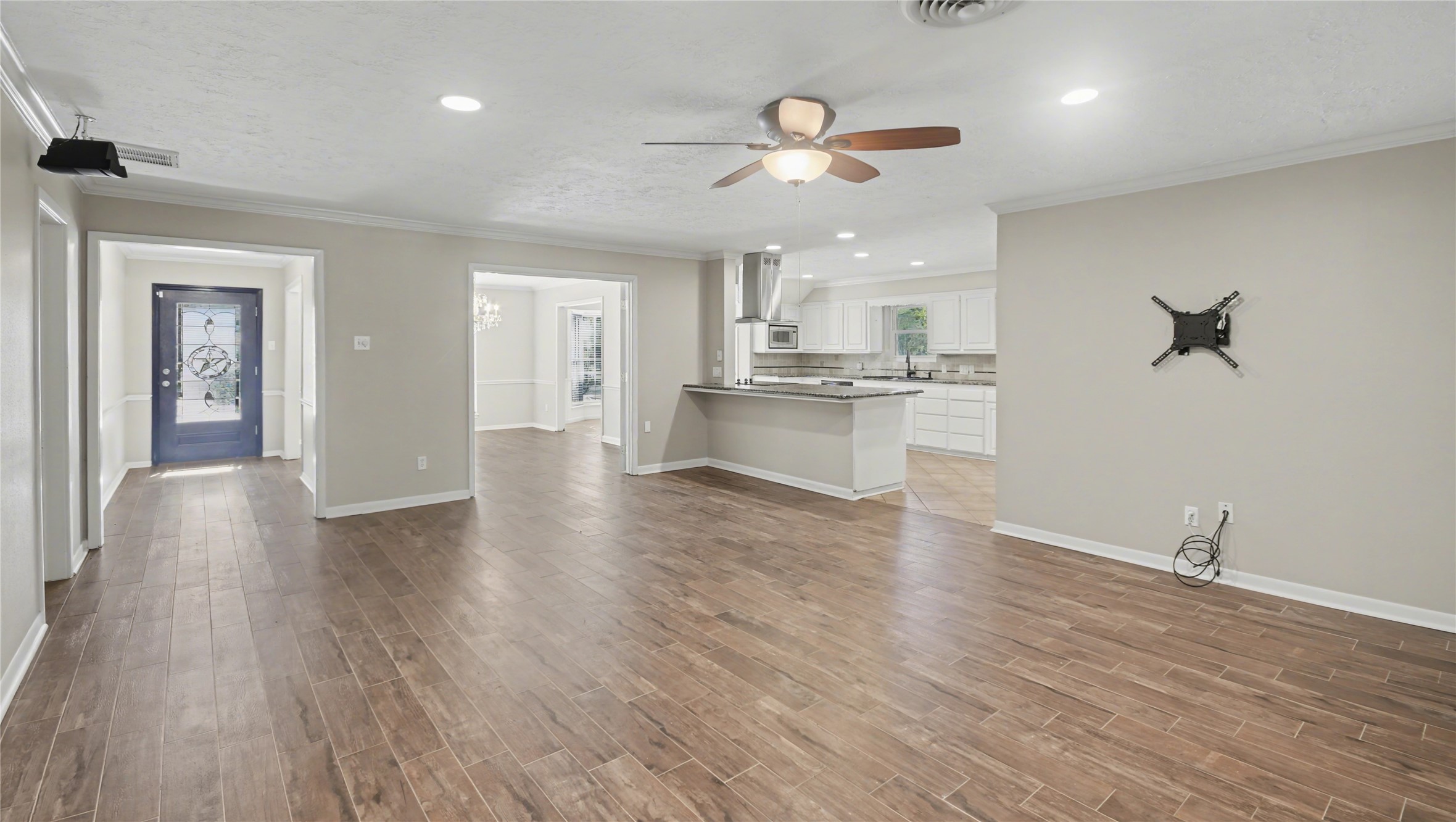 1431 Walnut Lane Houston, TX 77339 - Photo 8 of 46 Experience the perfect blend of style and functionality in this inviting living room, featuring sleek hardwood tile floors, a modern ceiling fan, and seamless access to an open-concept kitchen, ideal for both relaxing and entertaining.