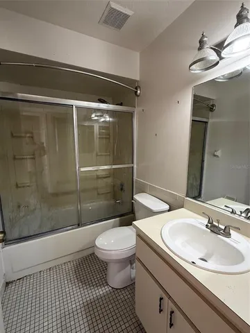 a bathroom with a sink a toilet a mirror and shower