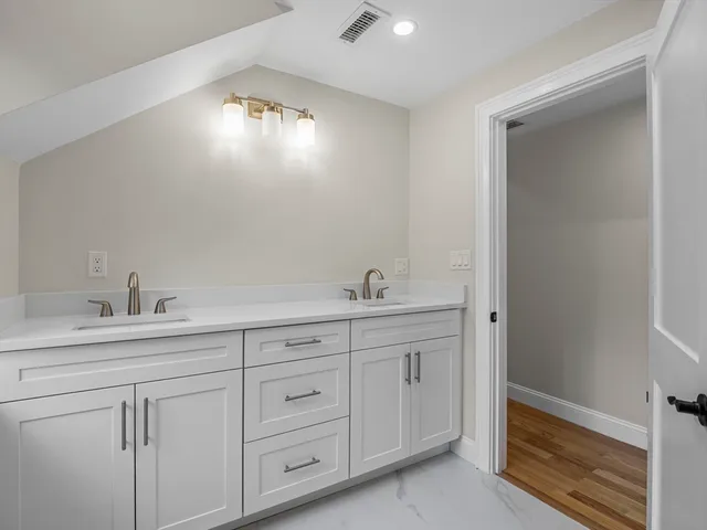 a spacious bathroom with double sink and a mirror
