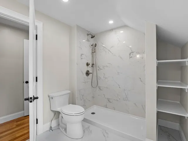 a bathroom with a toilet and a shower