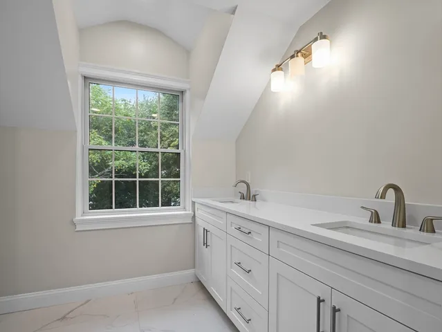 a bathroom with a sink and mirror with window