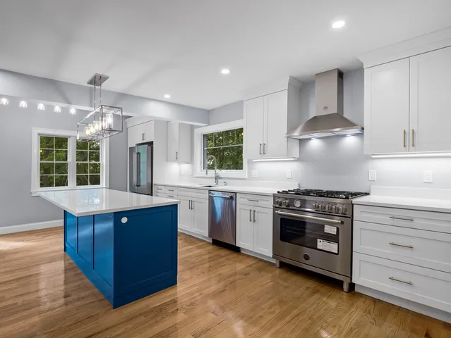 a kitchen with stainless steel appliances granite countertop a stove a sink and a refrigerator