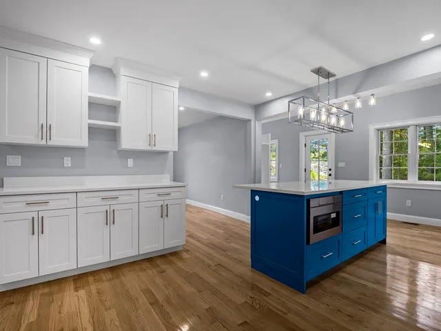 a kitchen with stainless steel appliances granite countertop a stove a sink dishwasher and a refrigerator with wooden floor