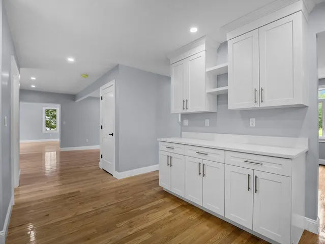 a kitchen with granite countertop white cabinets and white appliances