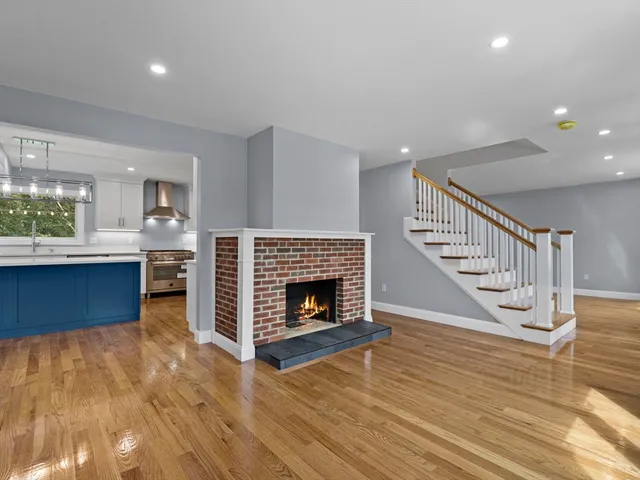 a living room with a fireplace and a kitchen view