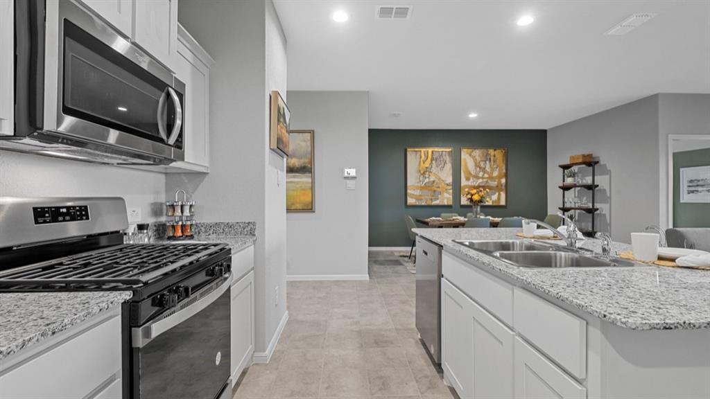 8509 Beltmill Parkway Fort Worth, TX 76131 - Photo 3 of 40 a kitchen with stainless steel appliances granite countertop a sink stove and cabinets