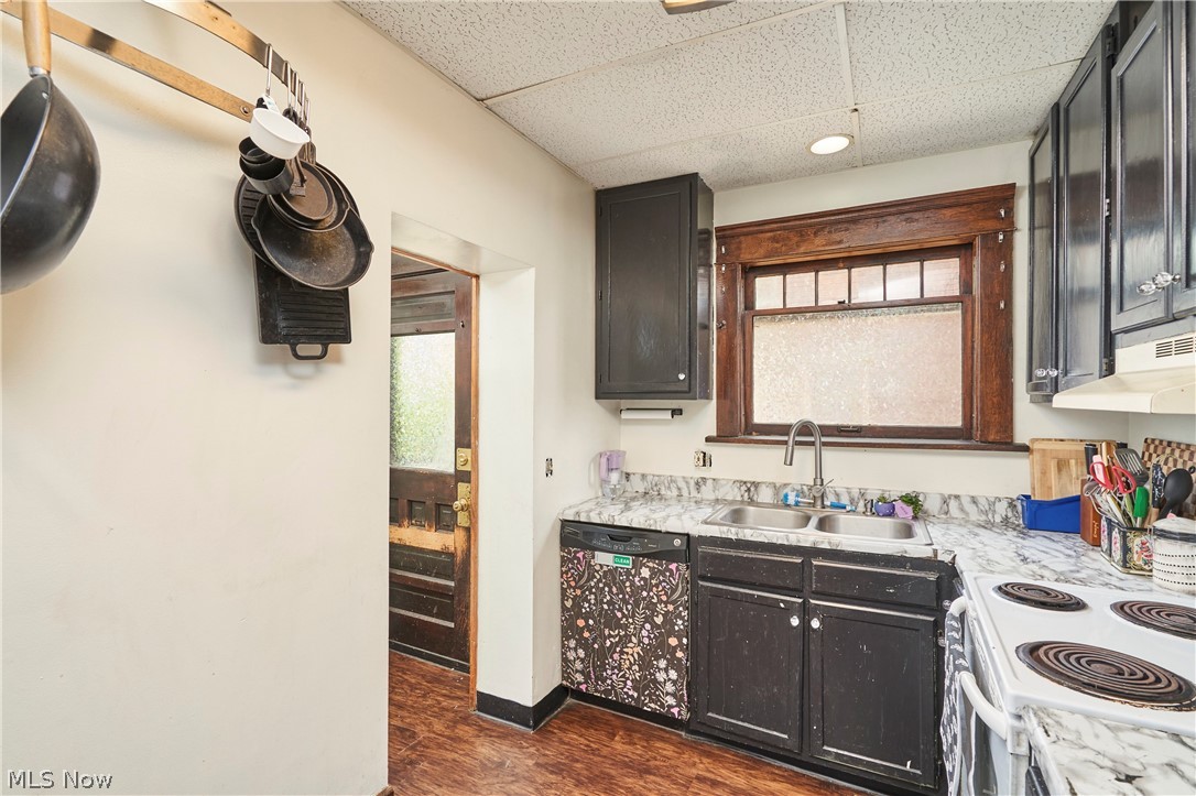 136 Smith Avenue Northwest Canton, OH 44708 - Photo 2 of 19 Kitchen featuring dark cabinetry, a dual basin stainless steel sink, and light-toned countertops
