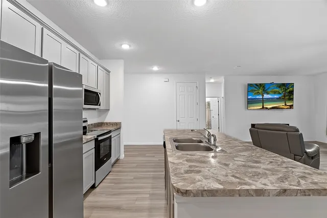 a kitchen with stainless steel appliances granite countertop a refrigerator and a stove
