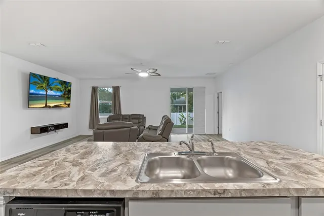 a kitchen with granite countertop a sink and a wooden floor