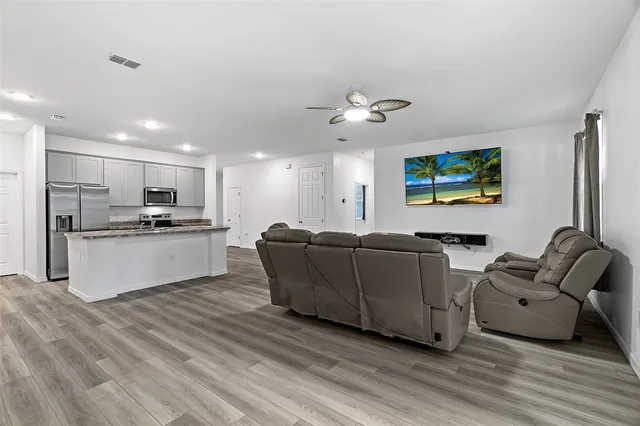 a living room with furniture and kitchen view