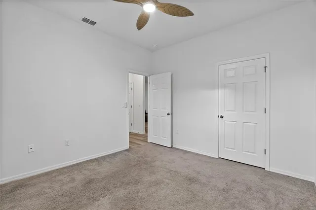 an empty room with chandelier fan