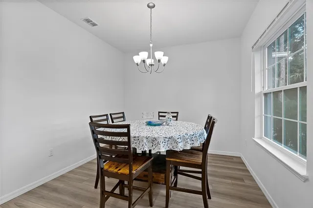 a view of a dining room with furniture wooden floor and a chandelier