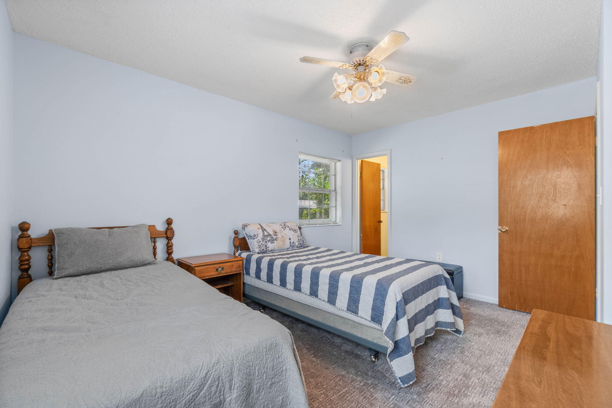 55 12th Street Shalimar, FL 32579 - Photo 17 of 22 a bedroom with two beds and a chandelier