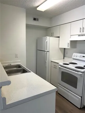 a kitchen with a stove cabinets and refrigerator