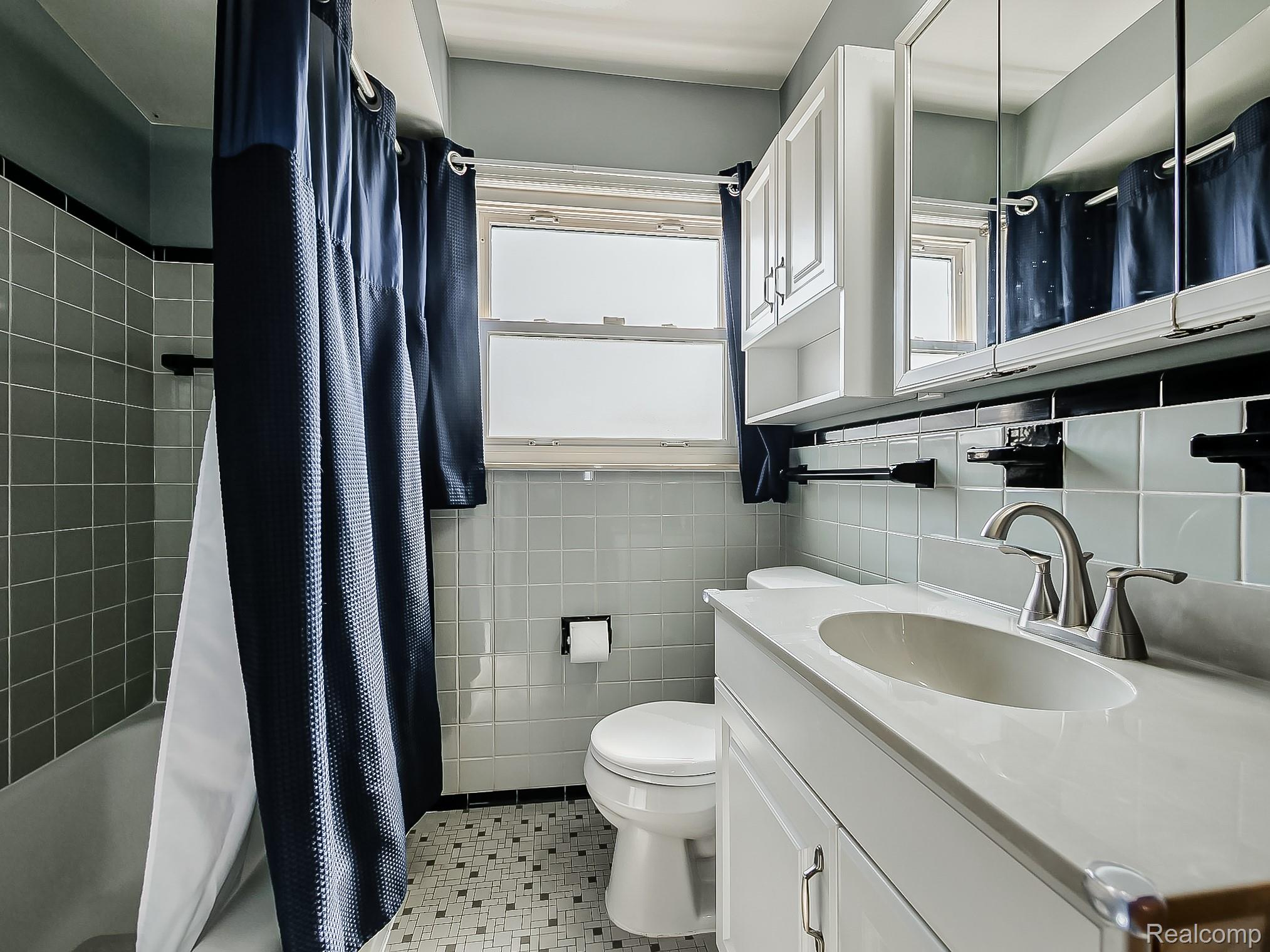 8634 Allen Road Allen Park, MI 48101 - Photo 10 of 38 Bathroom with vanity, shower / tub combo with curtain, light tile patterned floors, and tile walls