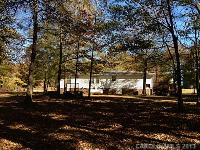 3400 Holden Road Lancaster, SC 29720 - Photo 2 of 14 a backyard of a house with a table and chairs under a large tree