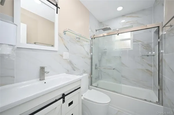 a bathroom with a sink a mirror toilet and shower