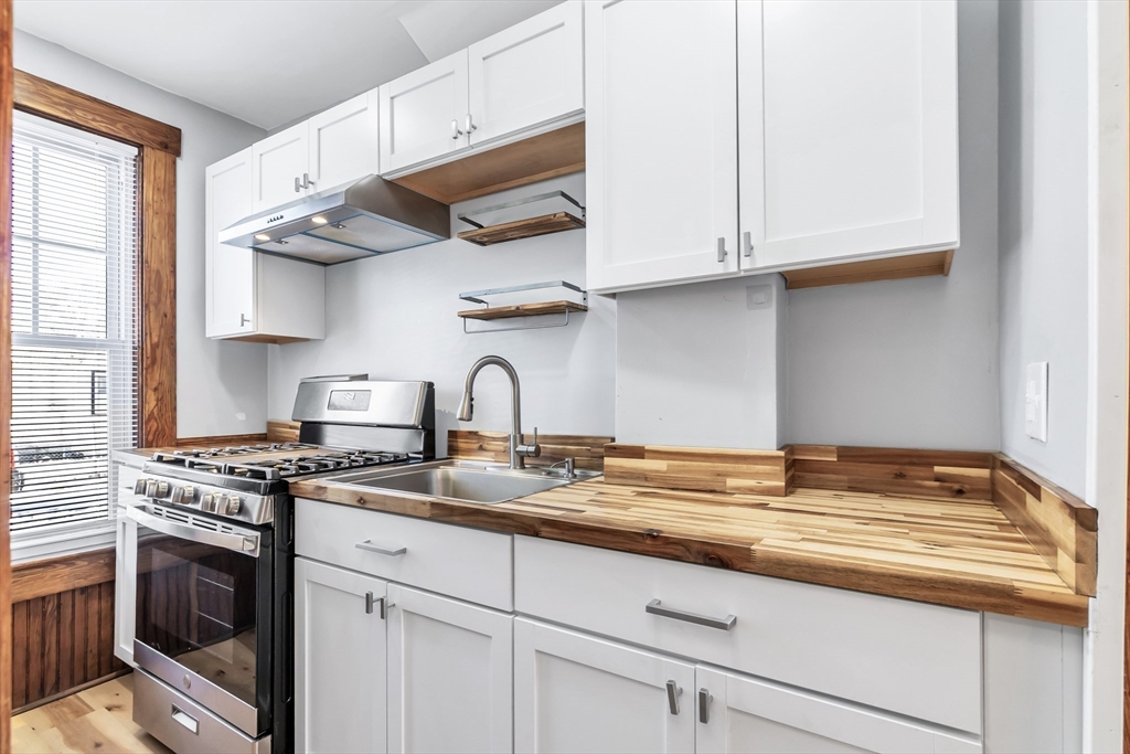 144 A Street Lowell, MA 01851 - Photo 15 of 32 a kitchen with stainless steel appliances granite countertop a sink a stove and cabinets