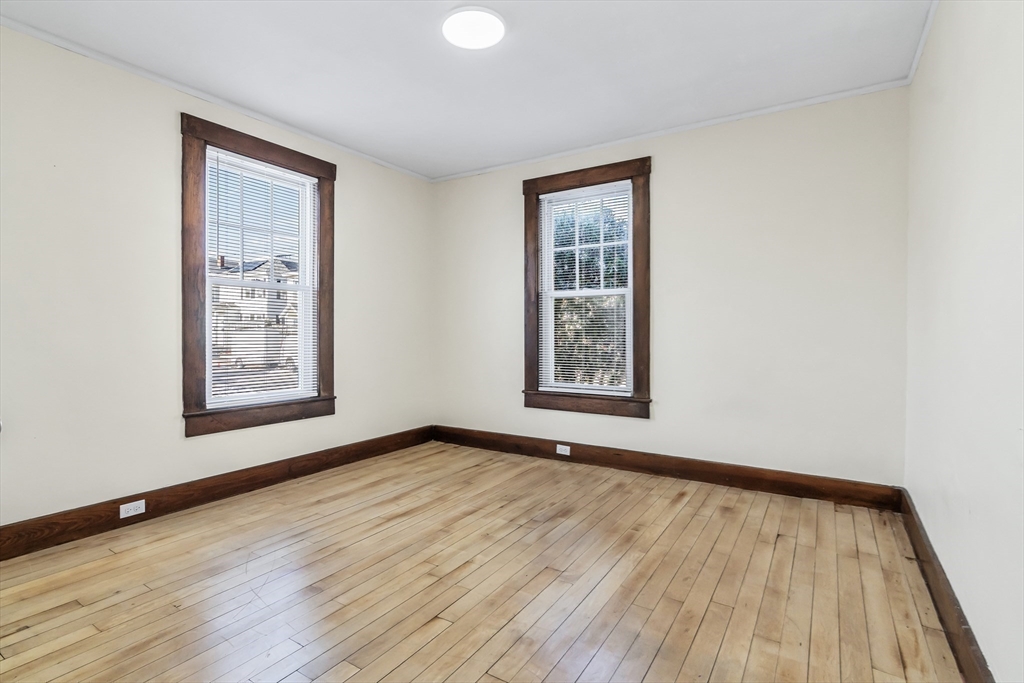 144 A Street Lowell, MA 01851 - Photo 17 of 32 a view of an empty room with wooden floor and a window