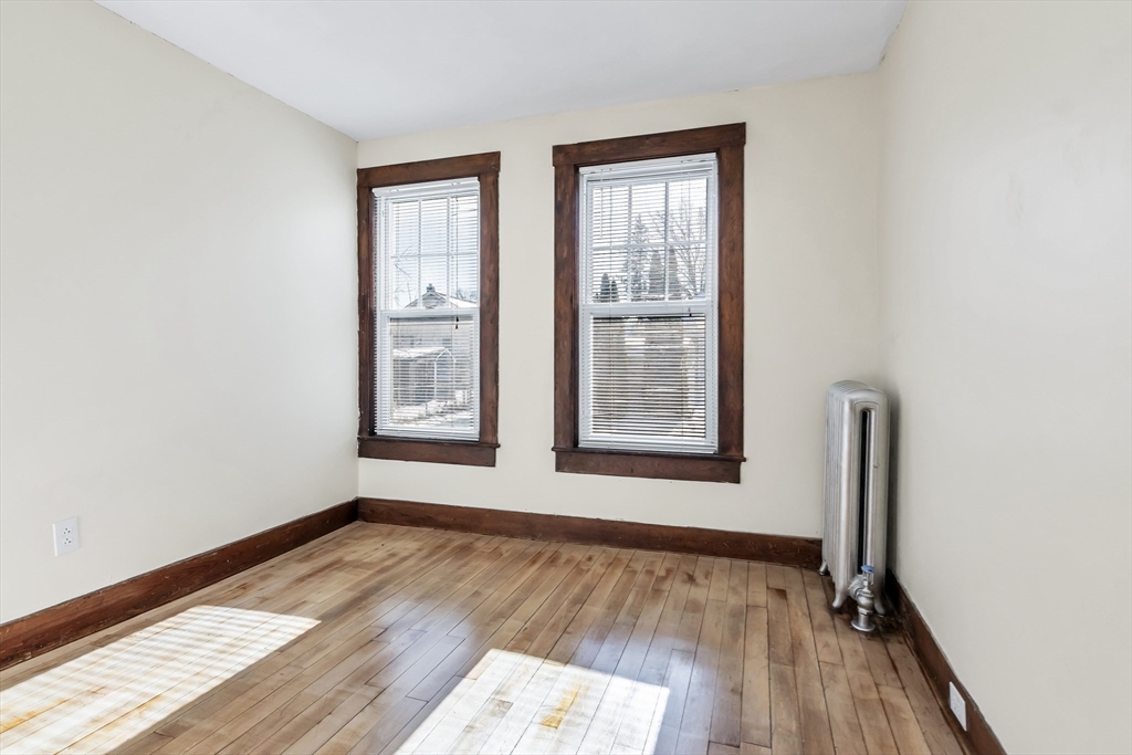 144 A Street Lowell, MA 01851 - Photo 27 of 32 an empty room with wooden floor and windows