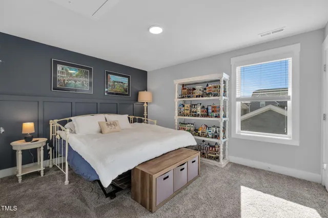 a bed sitting in a bedroom next to a window