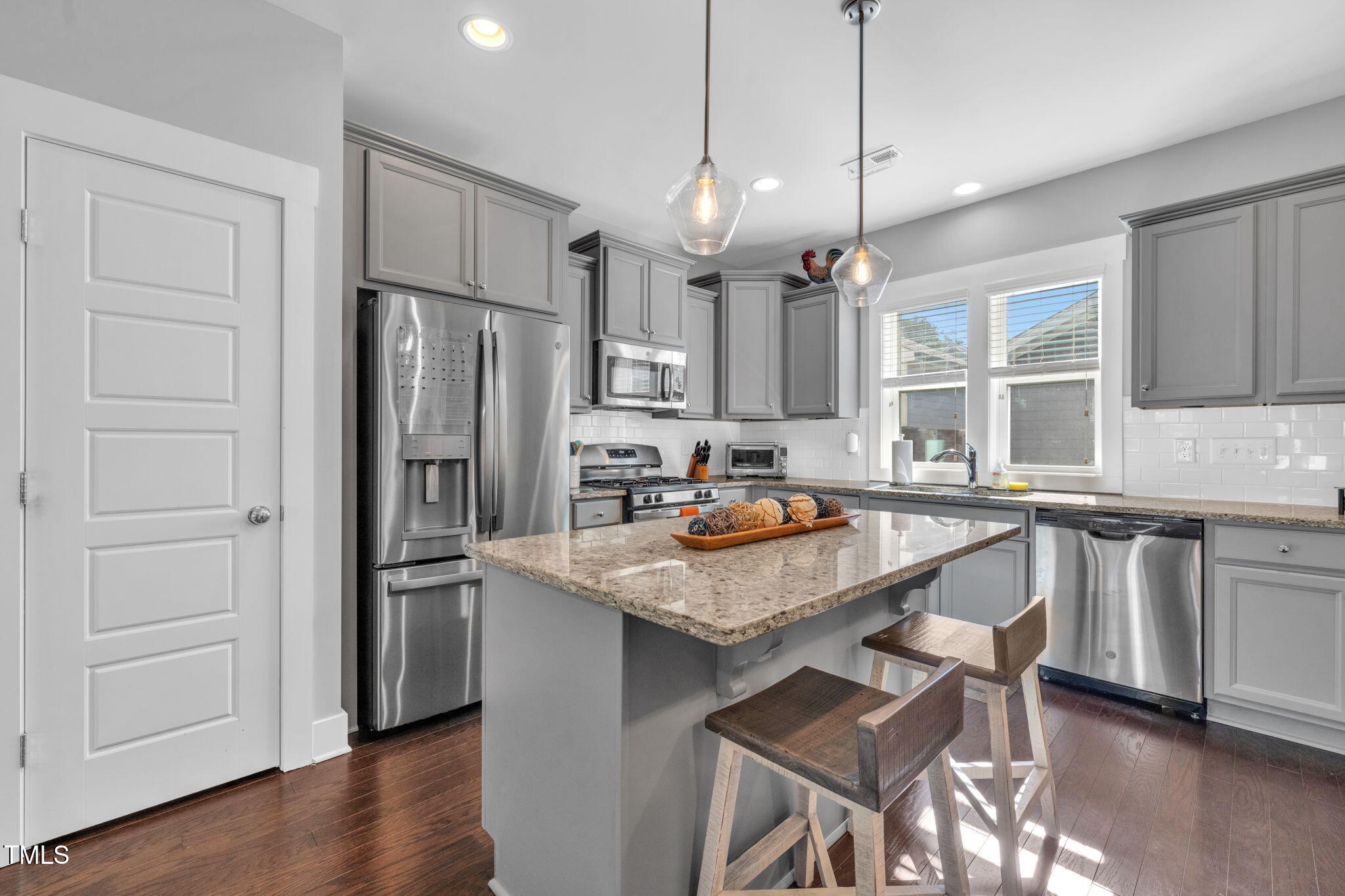 257 Douglas Falls Drive Wendell, NC 27591 - Photo 5 of 34 a kitchen with stainless steel appliances granite countertop a sink refrigerator and cabinets