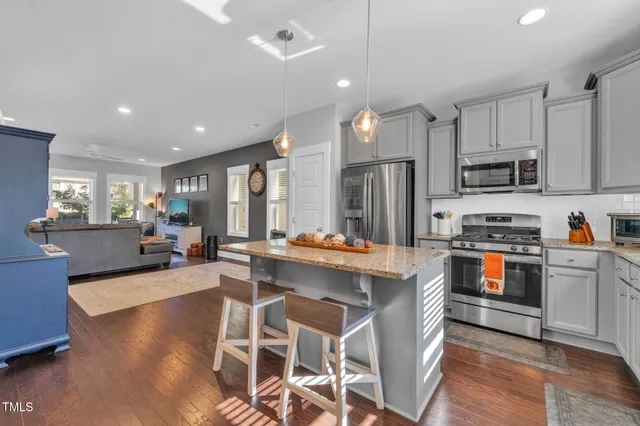a kitchen with stainless steel appliances granite countertop a sink stove and microwave