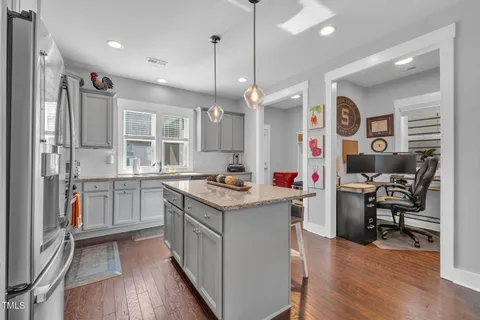 a kitchen with stainless steel appliances granite countertop a stove and a wooden floors