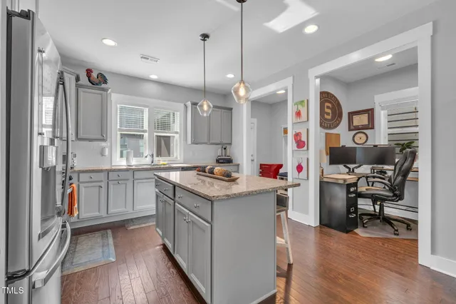a kitchen with stainless steel appliances granite countertop a stove and a wooden floors