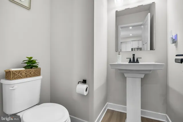 a bathroom with a sink toilet and a mirror