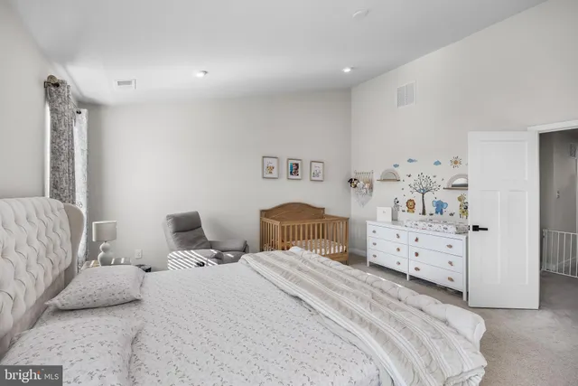 a bedroom with a bed a couch and dresser