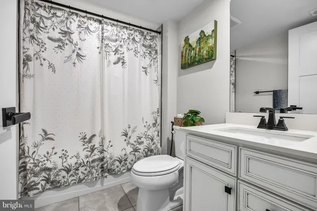 a view of a white house with large windows and a yard