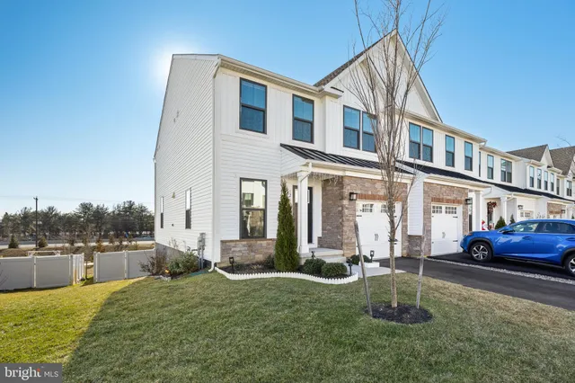 a view of a brick house with many windows next to a yard