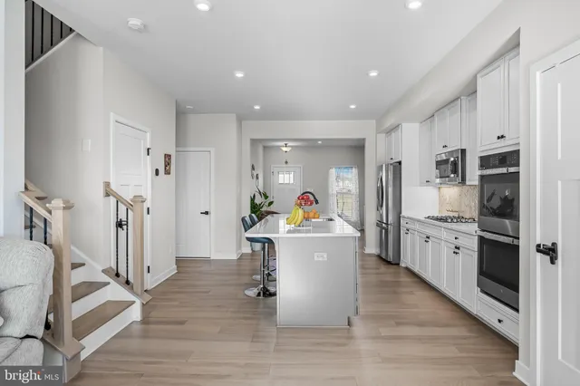 a view of a kitchen with refrigerator and wooden floor