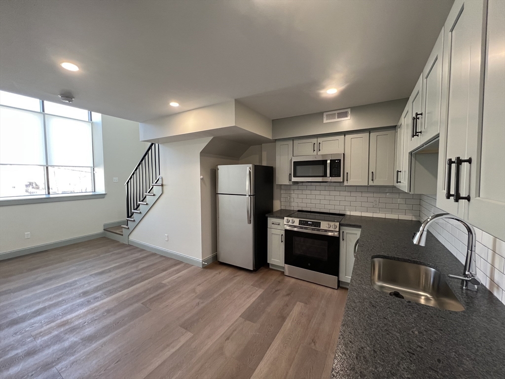 160 Seabury Street, Unit 40 Fall River, MA 02720 - Photo 2 of 14 a kitchen with stainless steel appliances granite countertop a stove a sink and a refrigerator