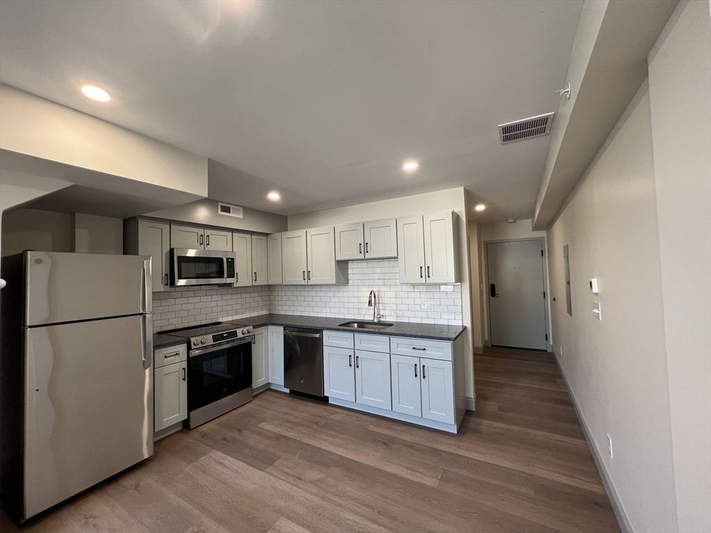 160 Seabury Street, Unit 40 Fall River, MA 02720 - Photo 2 of 13 a kitchen with kitchen island a sink stainless steel appliances and cabinets
