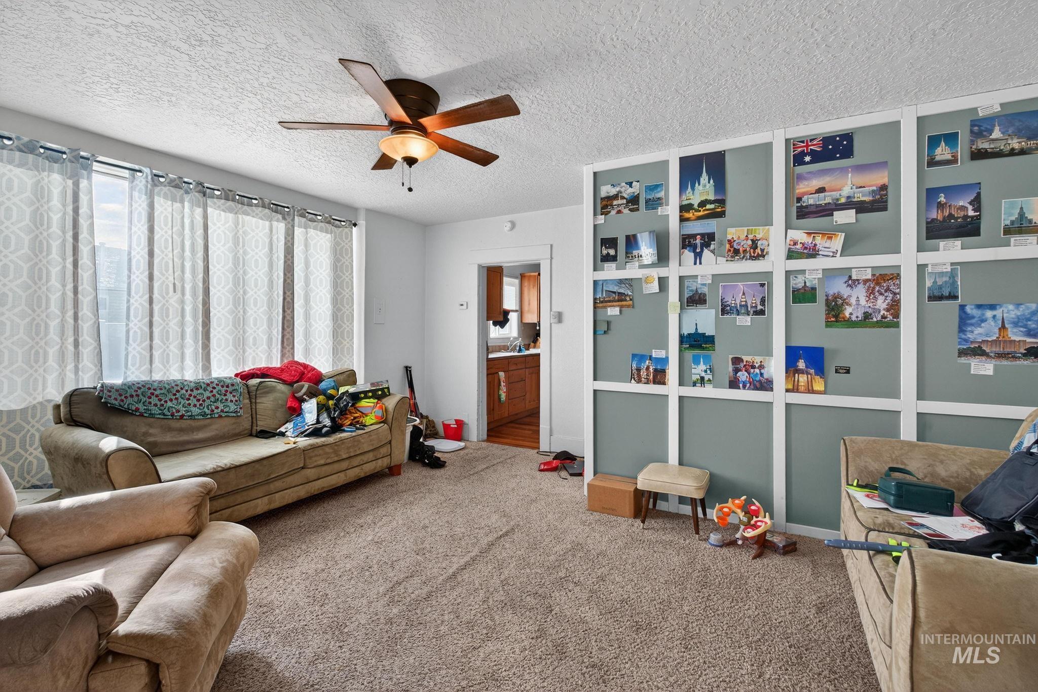 208 South 4th W Street Preston, ID 83263 - Photo 2 of 38 Carpeted living room featuring a textured ceiling and ceiling fan