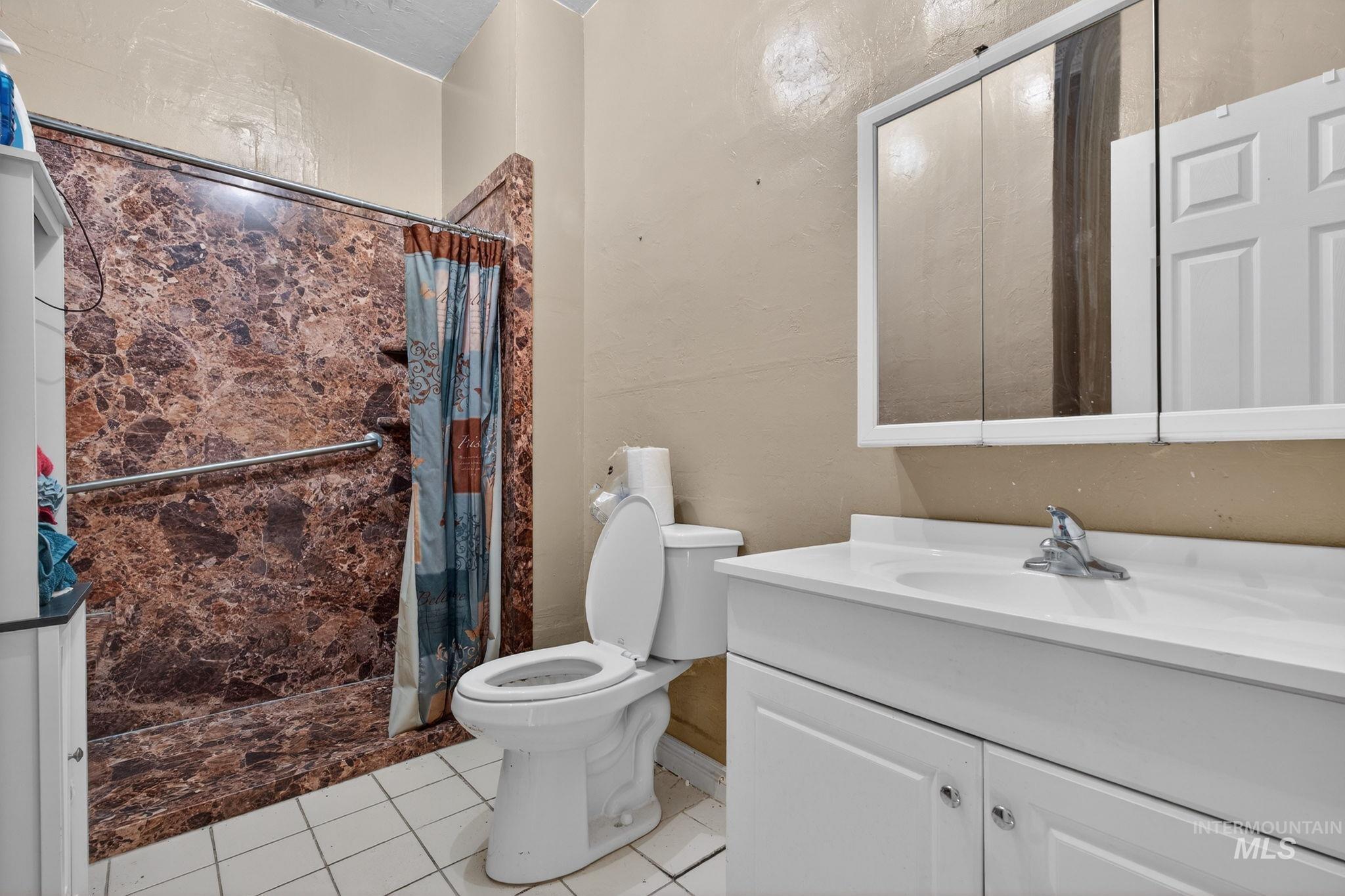 208 South 4th W Street Preston, ID 83263 - Photo 21 of 38 Bathroom featuring a stall shower, vanity, and light tile patterned floors