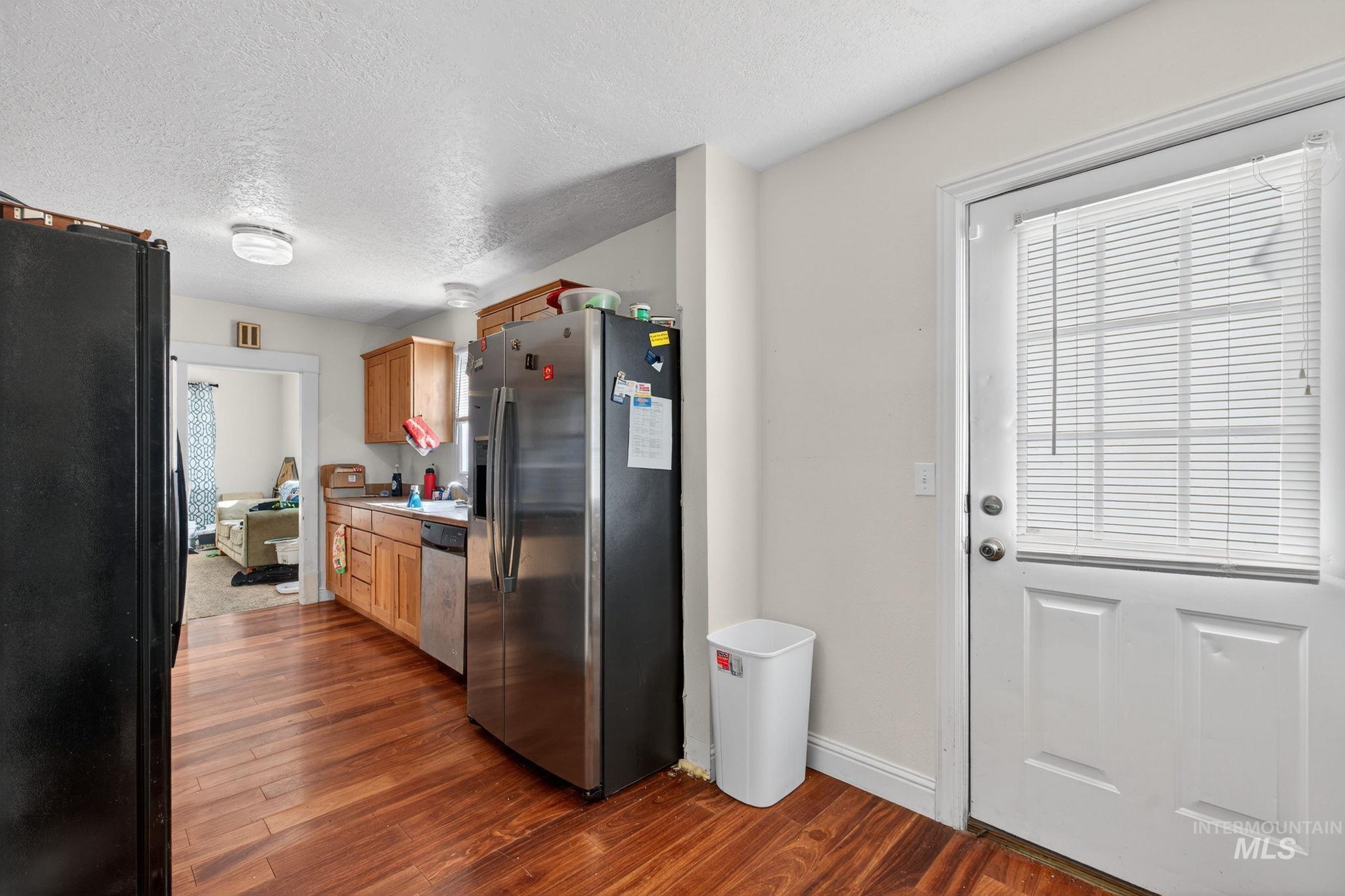 208 South 4th W Street Preston, ID 83263 - Photo 10 of 38 Kitchen with appliances with stainless steel finishes, a textured ceiling, dark wood-style floors, and light countertops