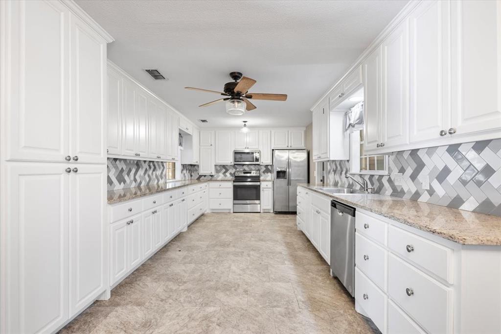 511 Happy Mount Mount Pleasant, TX 75455 - Photo 11 of 37 a large kitchen with cabinets and stainless steel appliances