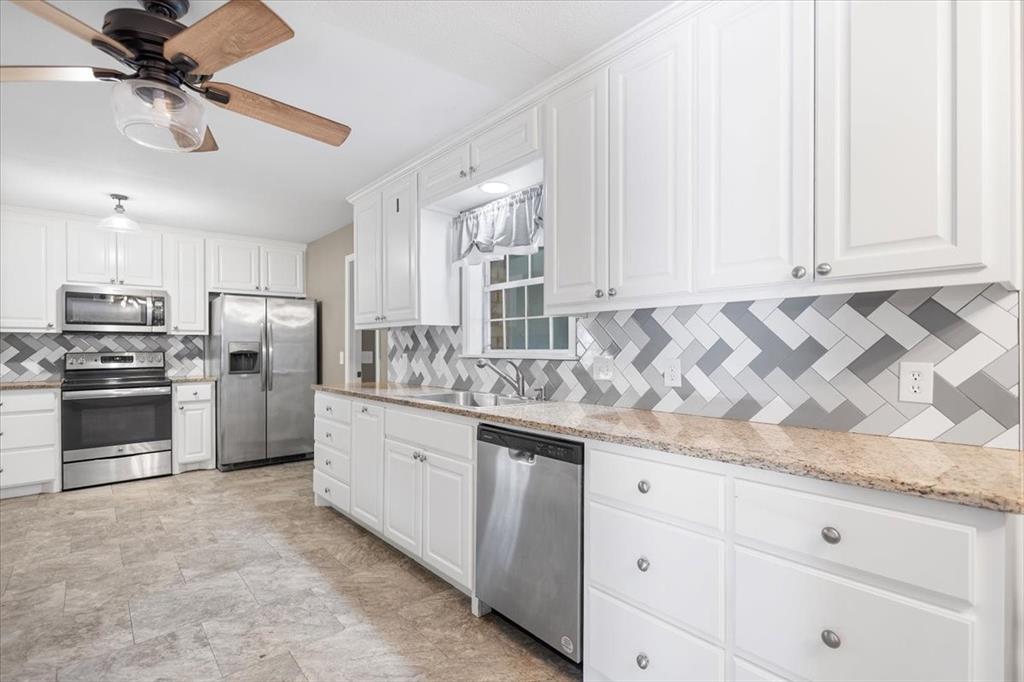 511 Happy Mount Mount Pleasant, TX 75455 - Photo 12 of 37 a kitchen with granite countertop white cabinets and stainless steel appliances