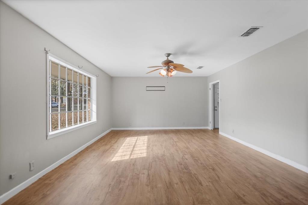 511 Happy Mount Mount Pleasant, TX 75455 - Photo 6 of 37 a view of an empty room with wooden floor and a window