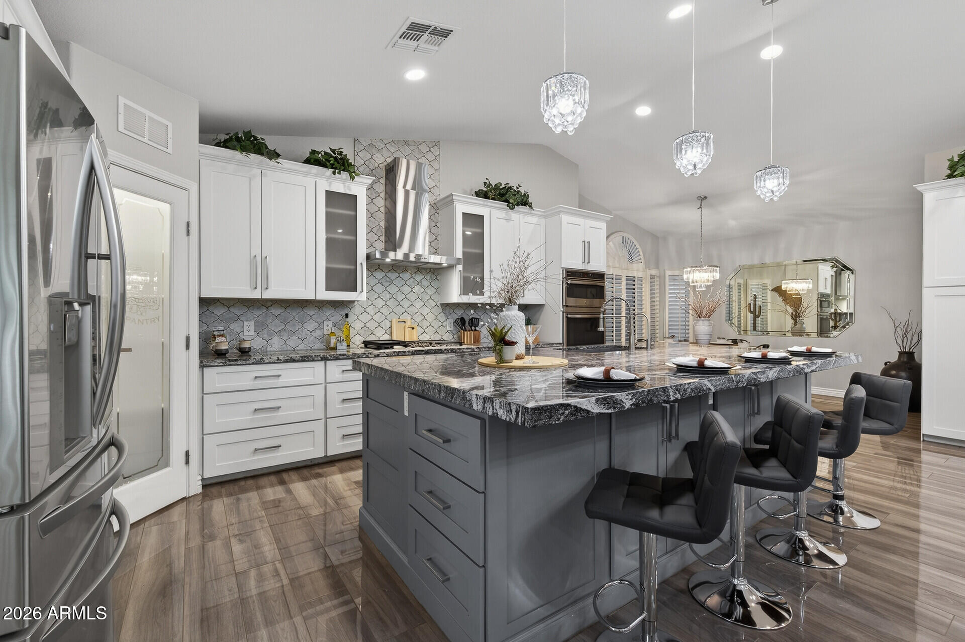 3533 North 159th Lane Goodyear, AZ 85395 - Photo 16 of 65 a kitchen with stainless steel appliances kitchen island granite countertop a table chairs sink and cabinets