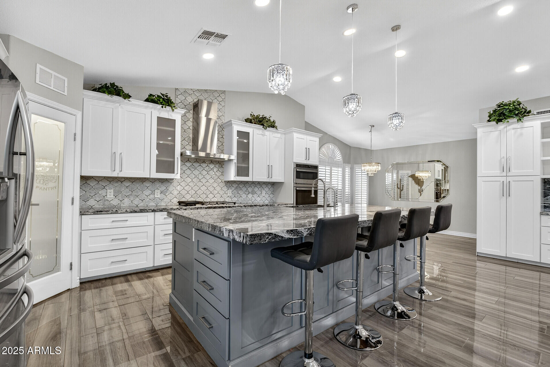 3533 North 159th Lane Goodyear, AZ 85395 - Photo 20 of 65 a kitchen with stainless steel appliances granite countertop a stove top oven a refrigerator a sink and a dining table with wooden floor