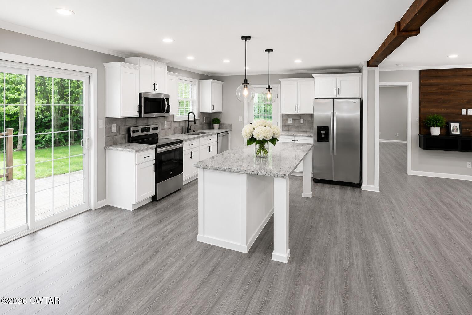398 Pope Road Lexington, TN 38351 - Photo 5 of 21 a kitchen with stainless steel appliances kitchen island granite countertop a refrigerator oven a sink dishwasher and white cabinets with wooden floor