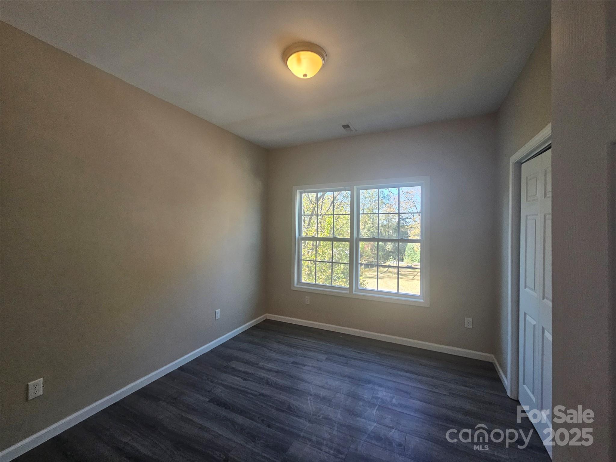106 Steinkuhler Street, Unit 6 Chester, SC 29706 - Photo 11 of 25 an empty room with wooden floor and windows