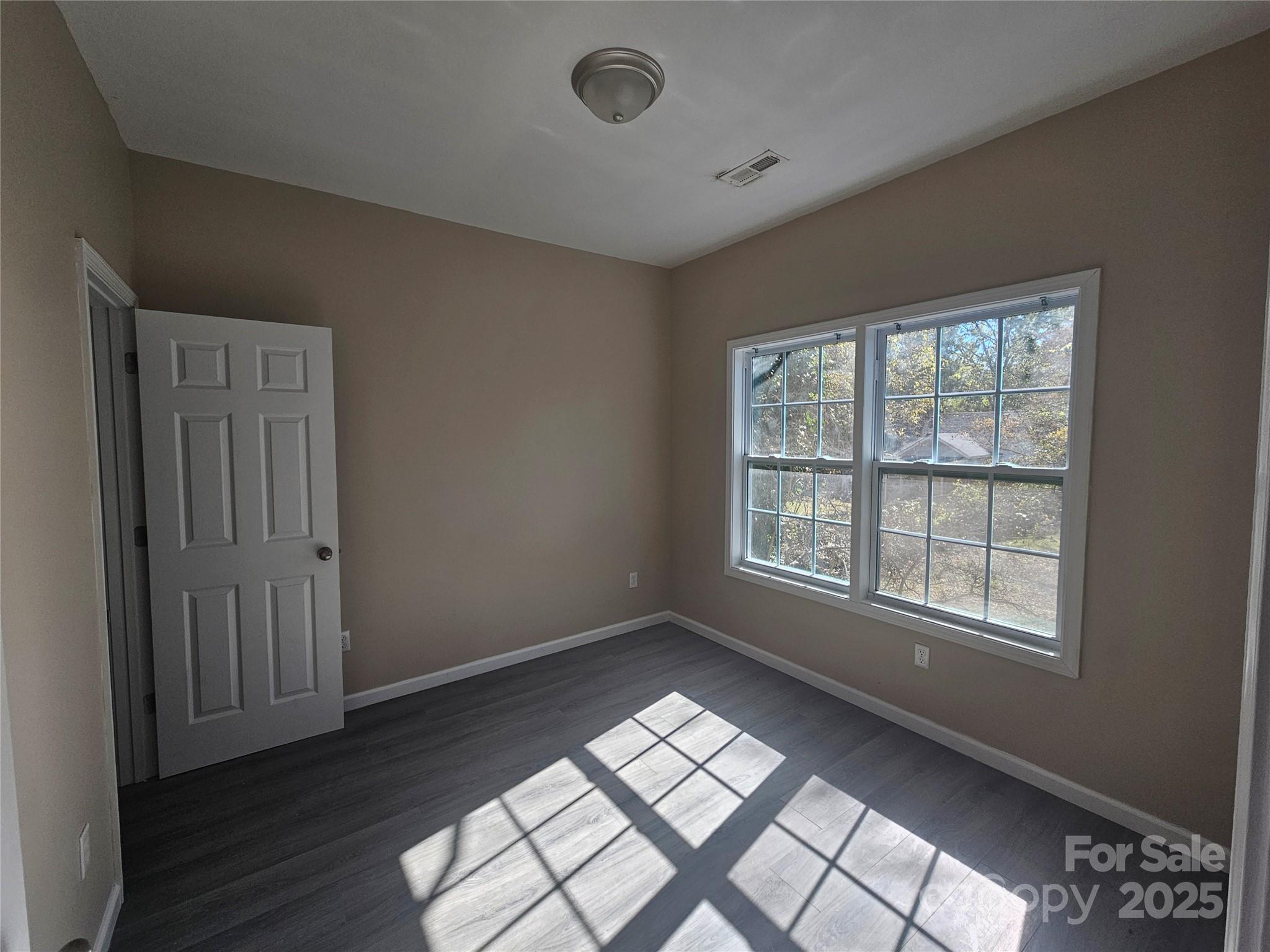 106 Steinkuhler Street, Unit 6 Chester, SC 29706 - Photo 9 of 25 a view of an empty room with wooden floor and a window